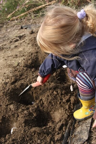 Child digging a hole for planting